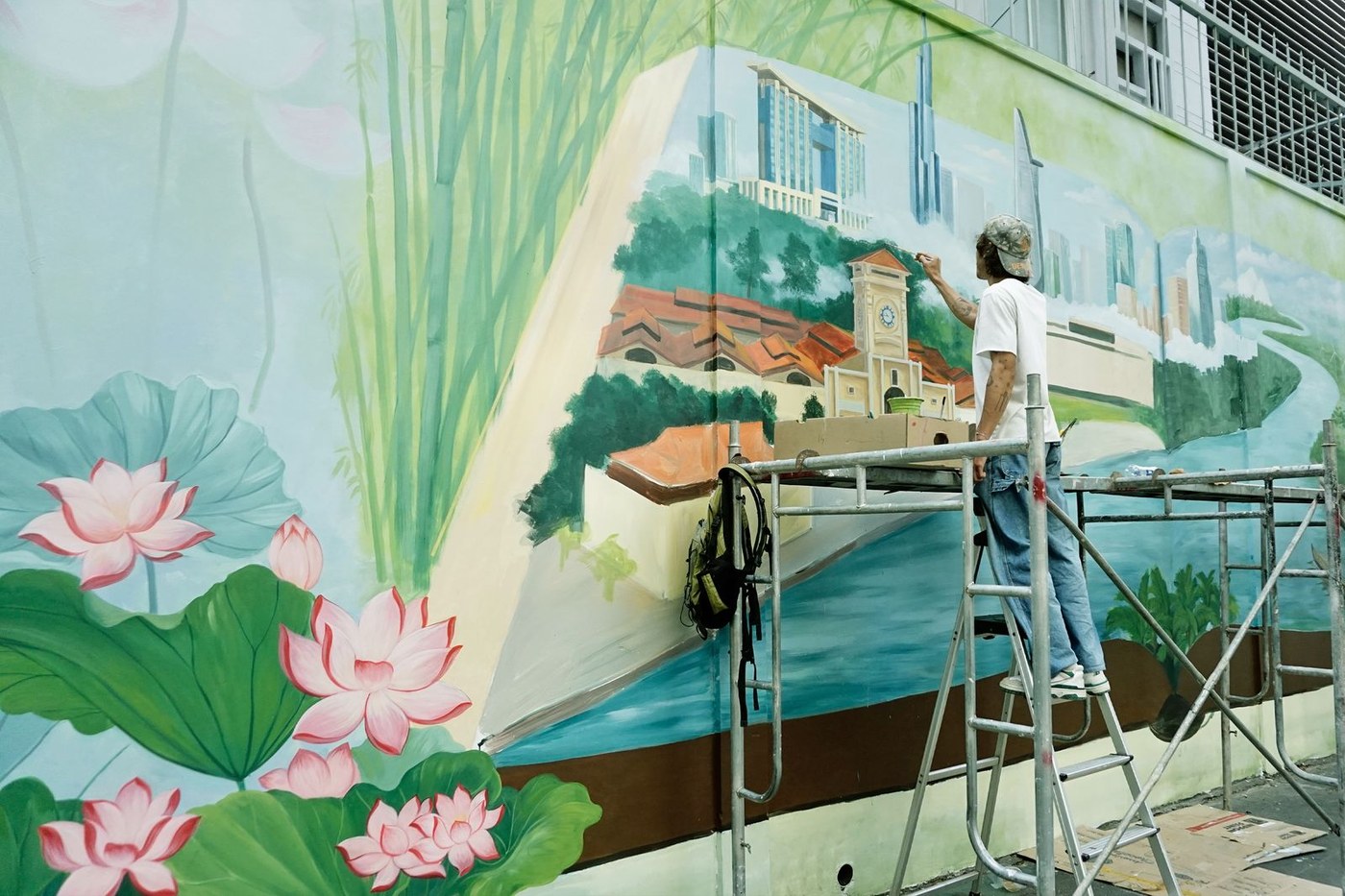 An artist paints a colorful mural on an outdoor wall, used here as a representative image of the kind of public art Gwinnett is seeking