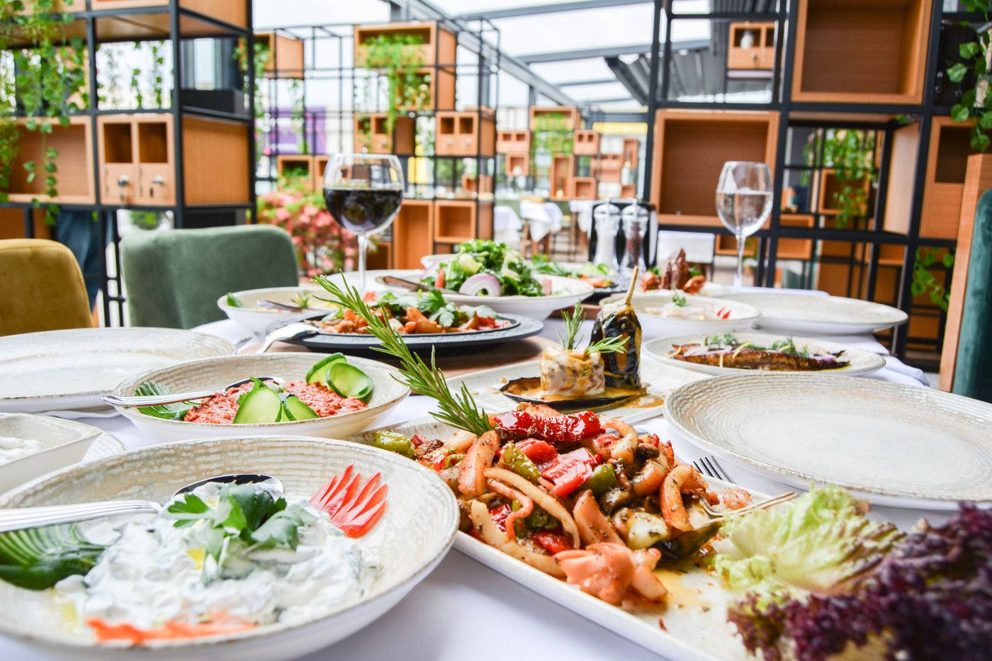 An elegantly set restaurant table with small plates, wine, and fine-dining dishes
